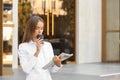 Young businesswoman drinking coffee and reading newspaper outdoors Royalty Free Stock Photo