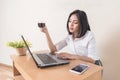 Young businesswoman drinking coffee while working with laptop at the desk. Coffee break at office concept