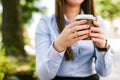 Young businesswoman drinks coffee to go