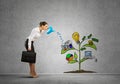 Young businesswoman in empty room watering drawn growth concept with can