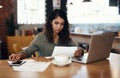 Young businesswoman, entrepreneur and coffee shop owner looking overwhelmed going through paperwork. Serious and