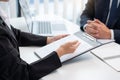 Young businesswoman explaining about her profile and holding resume during corporate meeting or job interview with applicant to Royalty Free Stock Photo