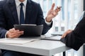 Young businesswoman explaining about her profile and holding resume during corporate meeting or job interview with applicant to Royalty Free Stock Photo