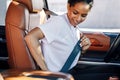 Young businesswoman fastening her seat belt