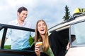 Young businesswoman getting out of taxi