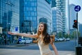 Young businesswoman hailing taxi. Business woman catch taxicar on city street. Successful and confident.