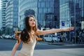 Young businesswoman hailing taxi. Business woman catch taxicar on city street. Successful and confident.