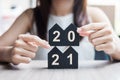 Young Businesswoman hands holding 2021 Happy New Year with house model on table office. New House, Financial, Property insurance, Royalty Free Stock Photo