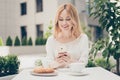 Young businesswoman having brunch at a cafe, using mobilephone, Royalty Free Stock Photo