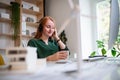 Young businesswoman with headphones sitting at the desk indoors in office. Royalty Free Stock Photo