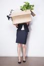 Young Businesswoman holding box of office items Royalty Free Stock Photo