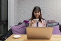 Young businesswoman holding a cup of coffee while sitting in front of laptop. home office and freelance concept Royalty Free Stock Photo