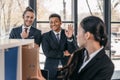 Young businesswoman holding folder while colleagues standing and looking behind Royalty Free Stock Photo