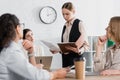 young businesswoman holding folder near team Royalty Free Stock Photo