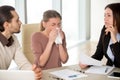 Young businesswoman holding handkerchief sneezing during meeting