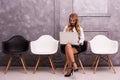 Young businesswoman holding laptop while sitting on chair Royalty Free Stock Photo