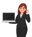 Young businesswoman holding a new brand laptop and showing raised hand fist gesture. Person making success sign. Female character. Royalty Free Stock Photo