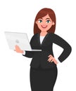 Young businesswoman holding a new digital laptop computer and posing hand on hip. Female character design illustration. Royalty Free Stock Photo