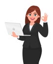 Young businesswoman holding a new digital laptop computer and showing okay, OK gesture sign. Female character design illustration.