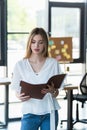 Young businesswoman holding paper folder in Royalty Free Stock Photo