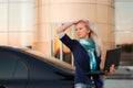 Young fashion business woman with laptop by her car Royalty Free Stock Photo
