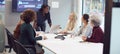 Young Businesswoman Leading Creative Meeting Of Women Collaborating Around Table In Modern Office Royalty Free Stock Photo