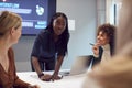 Young Businesswoman Leading Creative Meeting Of Women Collaborating Around Table In Modern Office Royalty Free Stock Photo