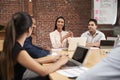 Young Businesswoman Leading Office Meeting Around Table