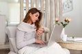 Young businesswoman looking at display of wristwatch and managing time while checking email on laptop.Freelancer with watch on