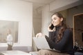 Young businesswoman making a call while sitting on office desk and working Royalty Free Stock Photo