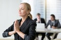 Young businesswoman meditating