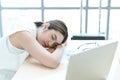 Young businesswoman overworked sleeping with laptop computer on desk in the office. Tired business Asian woman from working Royalty Free Stock Photo