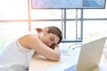 Young businesswoman overworked sleeping with laptop computer on desk in the office. Tired business Asian woman from working Royalty Free Stock Photo