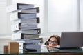 Businesswoman Peering The Folders Stack In Office