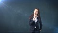 Young businesswoman portrait in suit standing and finger up near her lips with hush sign, background with copyspace. Royalty Free Stock Photo