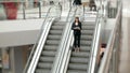 Young businesswoman portrait talking at the phone on escalators. Business woman full lenght in shopping mall or office