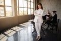 Young Businesswoman Posing In Front Of Team Standing In Office Royalty Free Stock Photo