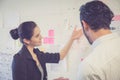 Young businesswoman with present profit and secretary while giving presentation in office.