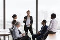 Young businesswoman presenting project report to different aged diverse team Royalty Free Stock Photo