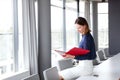 Young businesswoman reading file while sitting on conference table in office Royalty Free Stock Photo