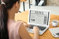 Young businesswoman reading news on laptop screen in office Royalty Free Stock Photo