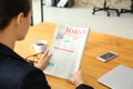 Young businesswoman reading newspaper in office Royalty Free Stock Photo