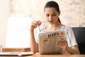 Young businesswoman reading newspaper in office Royalty Free Stock Photo