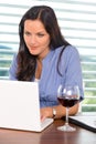 Young businesswoman relaxing home wine surfing internet