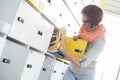 Young businesswoman removing file from locker at creative office