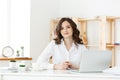 Young businesswoman or secretary sitting at desk and working. Smiling and looking at camera Royalty Free Stock Photo