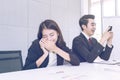 Young businesswoman is secretly talking on the phone at work.