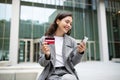 Young businesswoman shopping online making payment on phone sitting outside Royalty Free Stock Photo