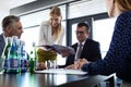 Young businesswoman showing project to businessman during meeting in office Royalty Free Stock Photo