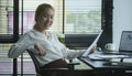 Young businesswoman sitting in bright modern office and looking confidently at camera Royalty Free Stock Photo